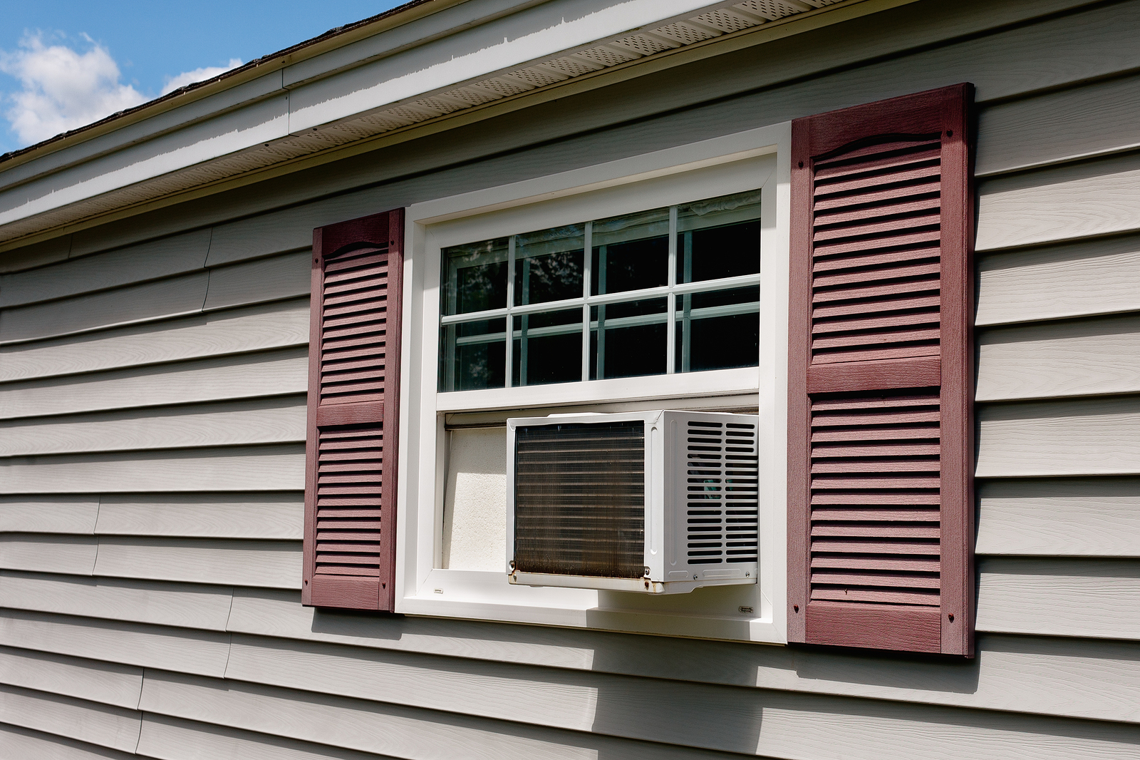 Air conditioner in house window on Summer day.
